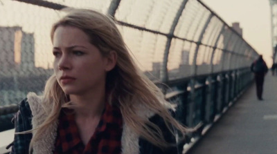 a woman walking across a bridge next to a tall building