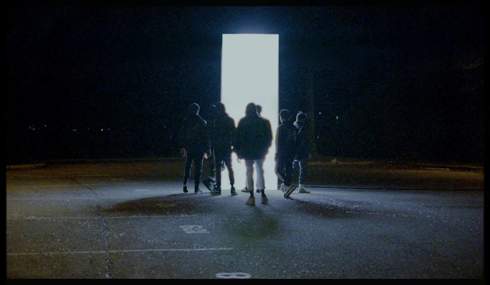 a group of people standing in a parking lot