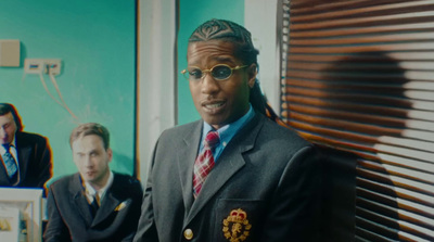 a man in a suit and tie standing in front of a window