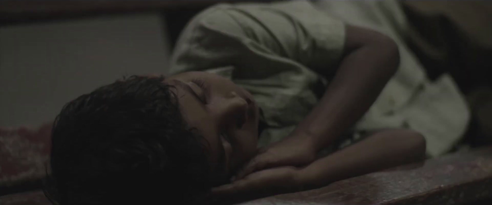 a young boy is sleeping on a bed