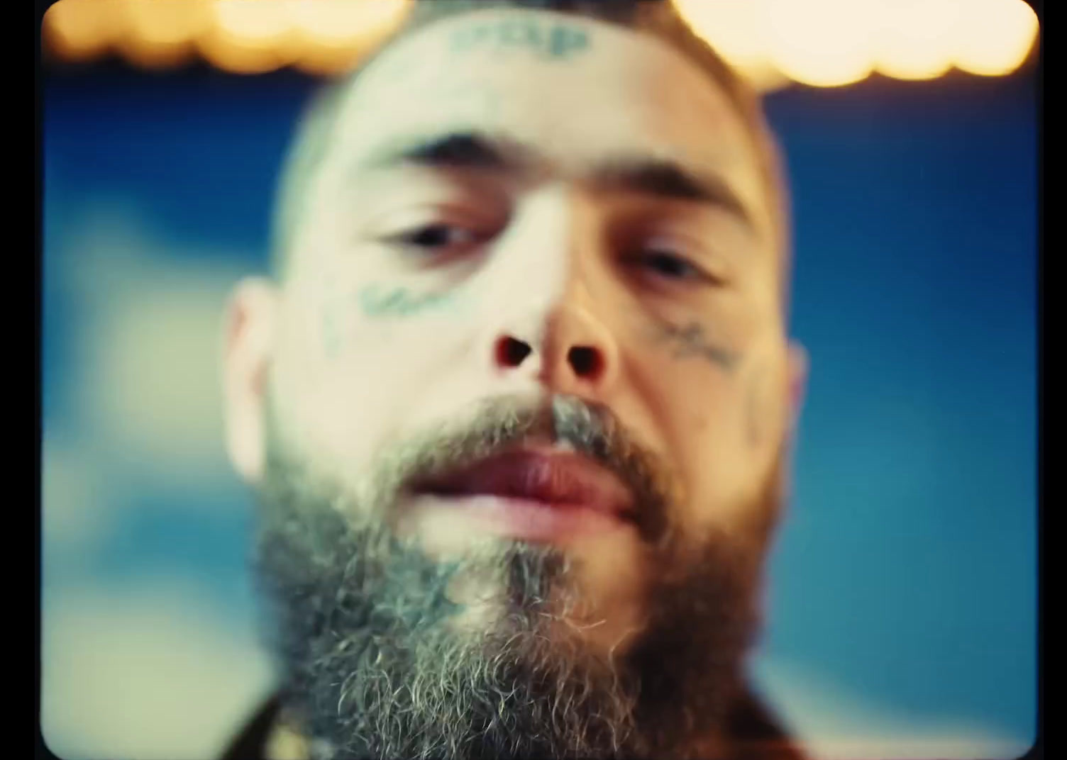 a man with a beard and tattoos on his face