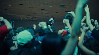 a crowd of people standing around each other with their hands in the air