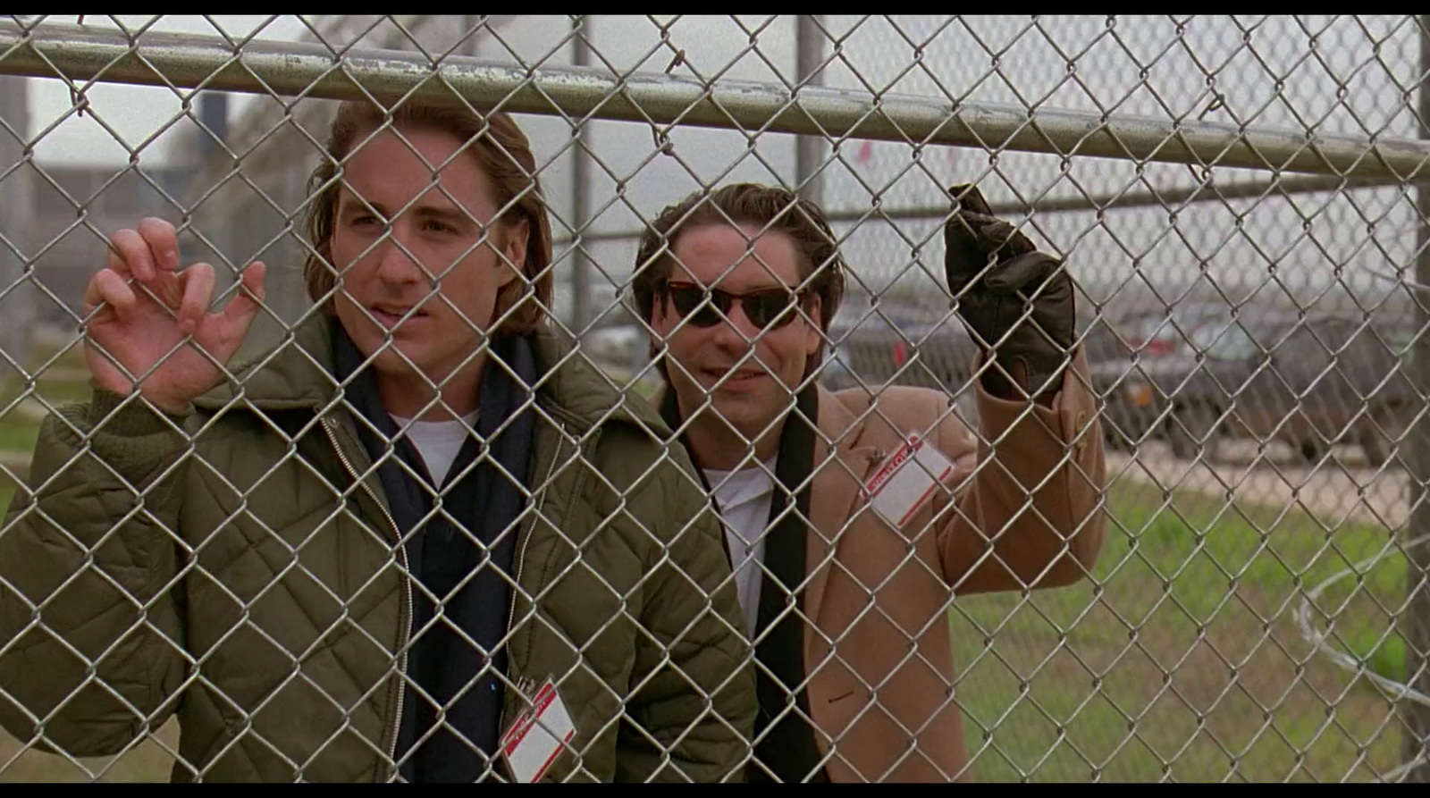 a couple of people behind a chain link fence