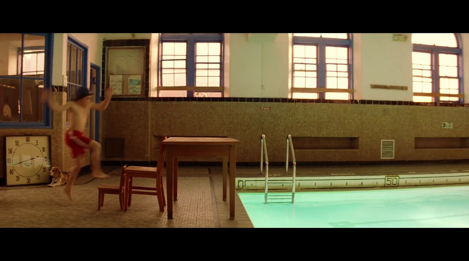 a young boy jumping into a swimming pool