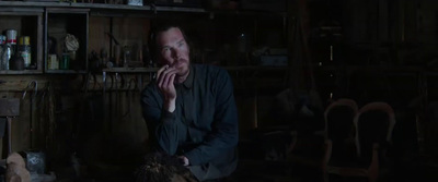 a man sitting in a dark room with his hands on his face