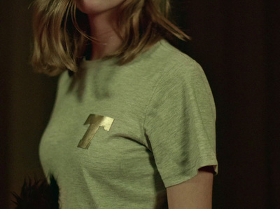 a woman wearing a t - shirt with a cross on it