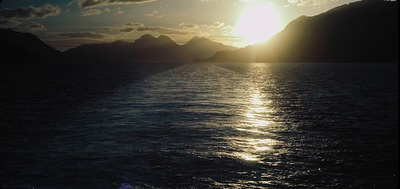 a large body of water with mountains in the background