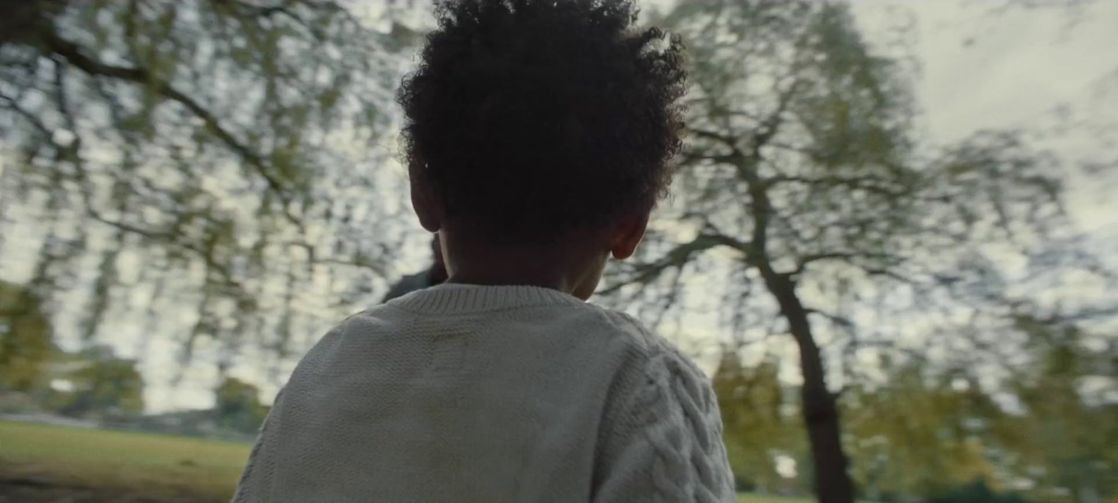 a young person standing in front of a tree