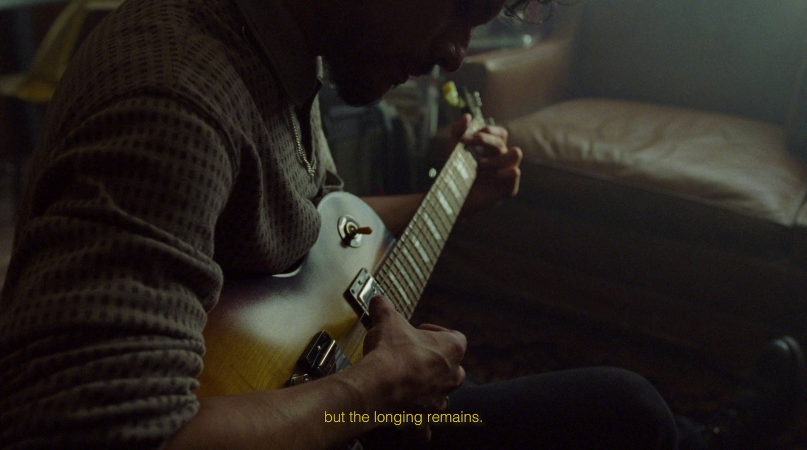 a man playing a guitar in a living room