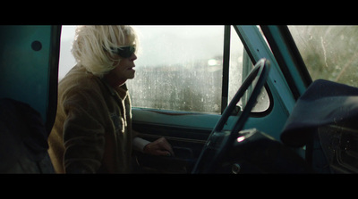 a man with blonde hair sitting in a car