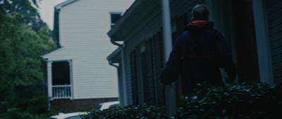 a person standing outside of a white house