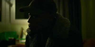 a man wearing a hat and scarf in a dark room