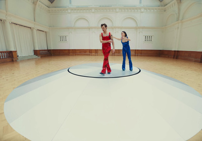 a couple of women standing on top of a wooden floor