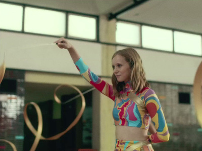 a woman in a multicolored top is holding a string