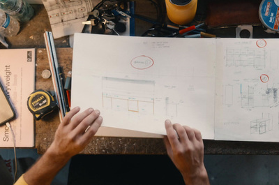 a person holding a piece of paper over a desk