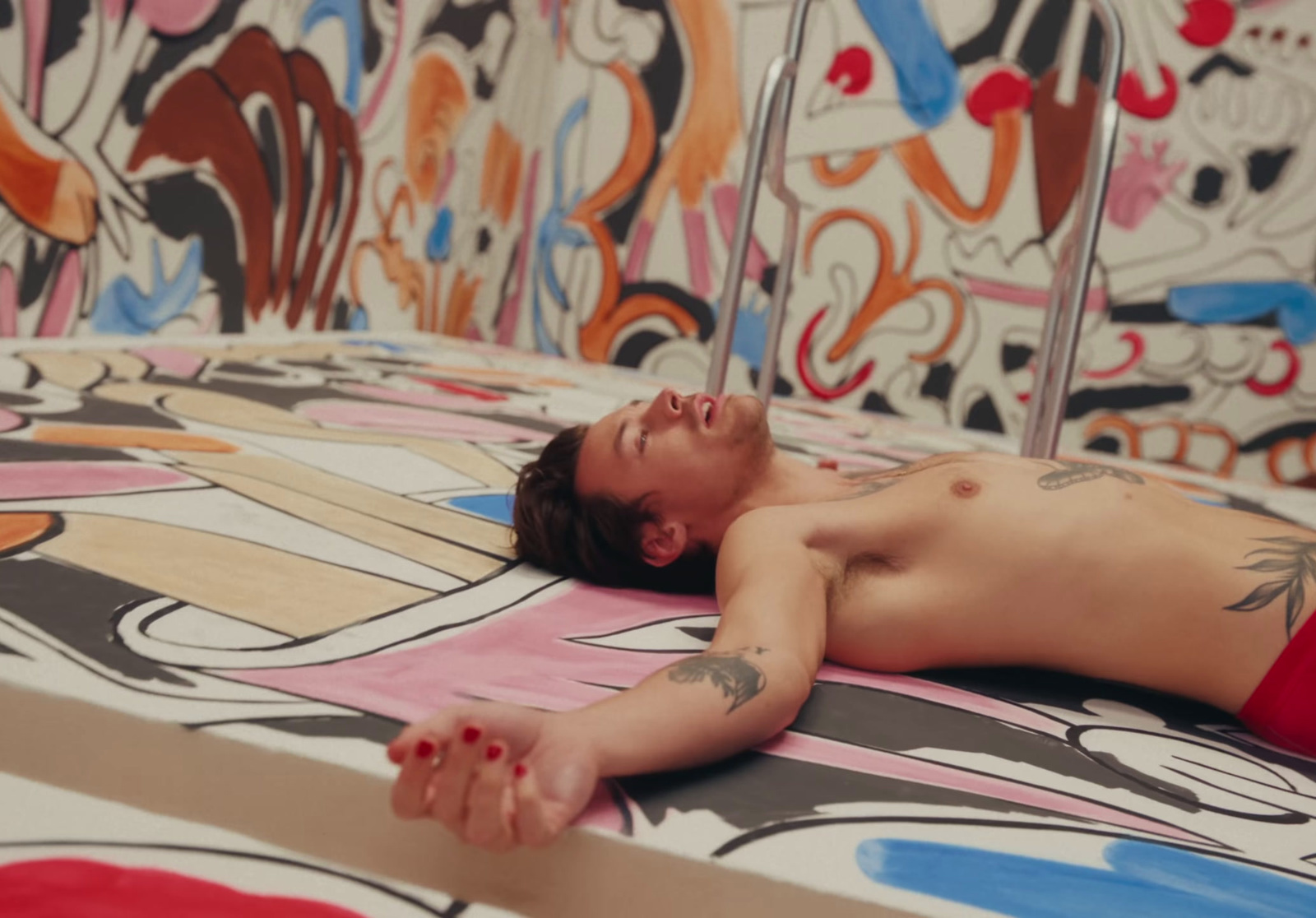 a man laying on top of a bed covered in graffiti