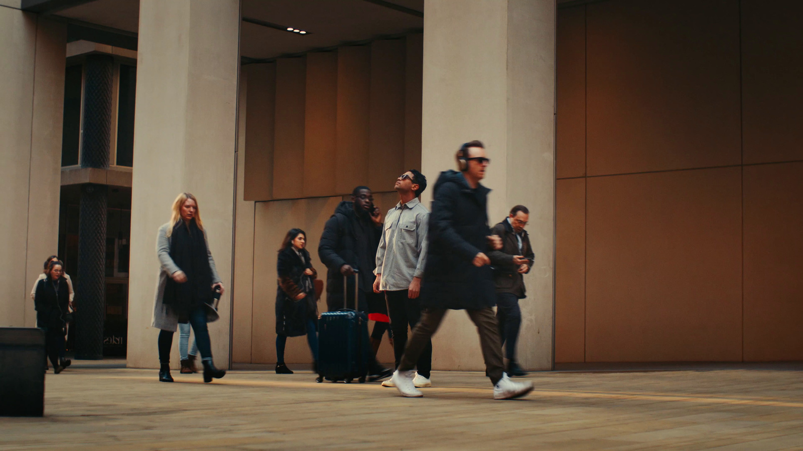 a group of people walking down a sidewalk