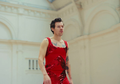 a man in a red dress standing in a room