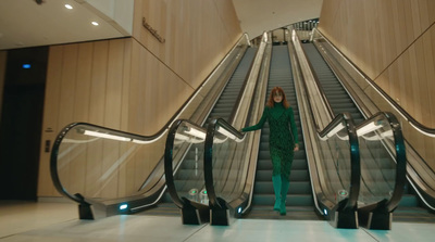 a woman standing on an escalator in a building