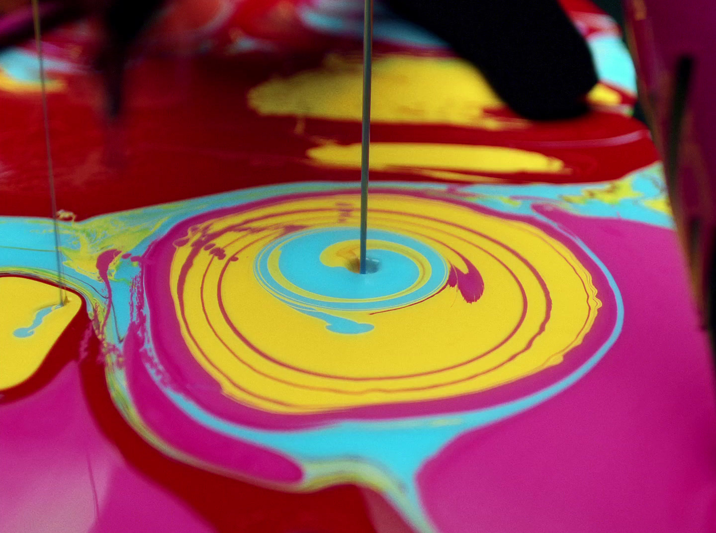 a close up of a colorful surface with a needle sticking out of it