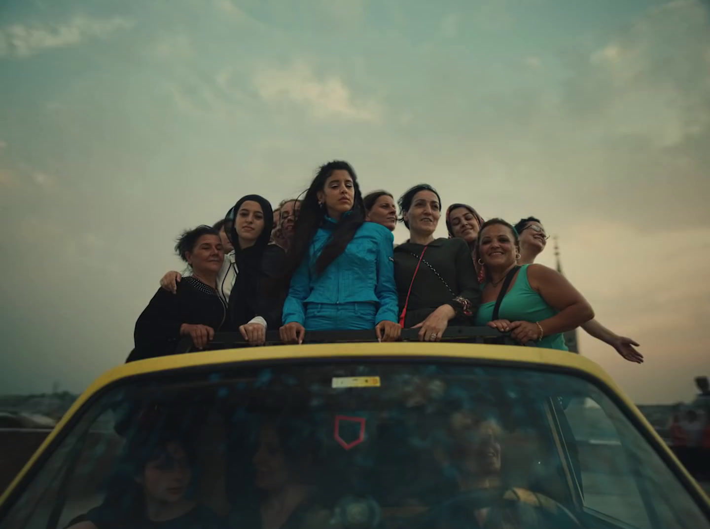 a group of people standing on top of a car