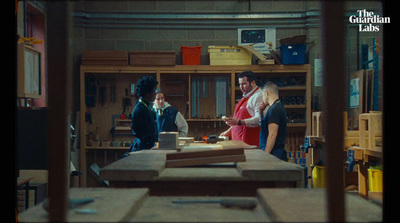 a group of people standing around a wooden table