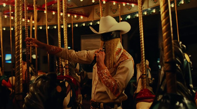 a man in a cowboy hat talking on a cell phone