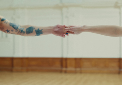 a man and a woman holding hands in a dance studio