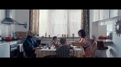 a group of people sitting around a table in a kitchen