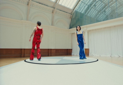 a couple of women standing on top of a white floor