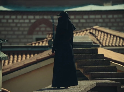 a person in a black robe standing on a ledge