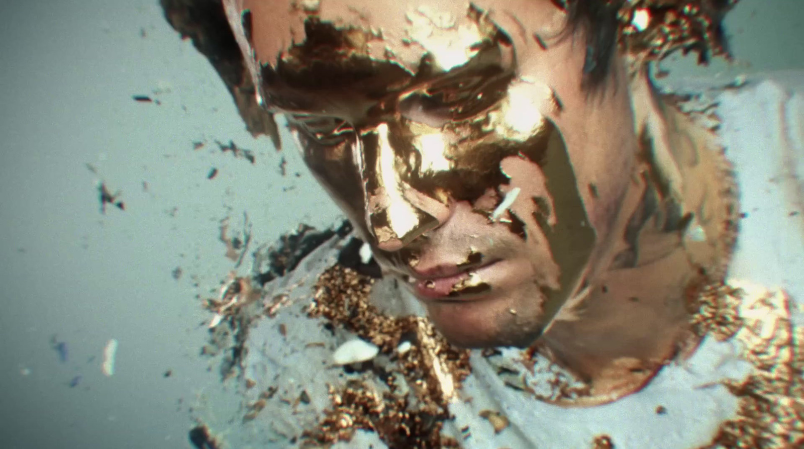 a man with gold paint all over his face