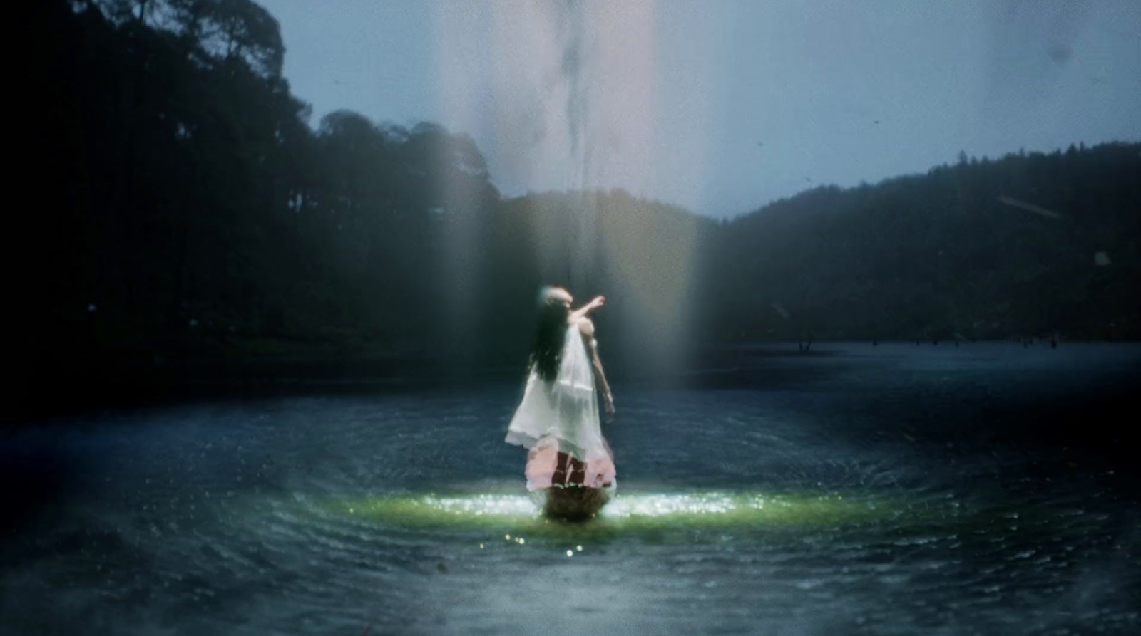 a woman in a white dress standing in a body of water