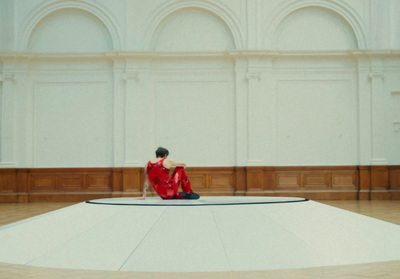 a woman in a red dress is sitting on a round platform