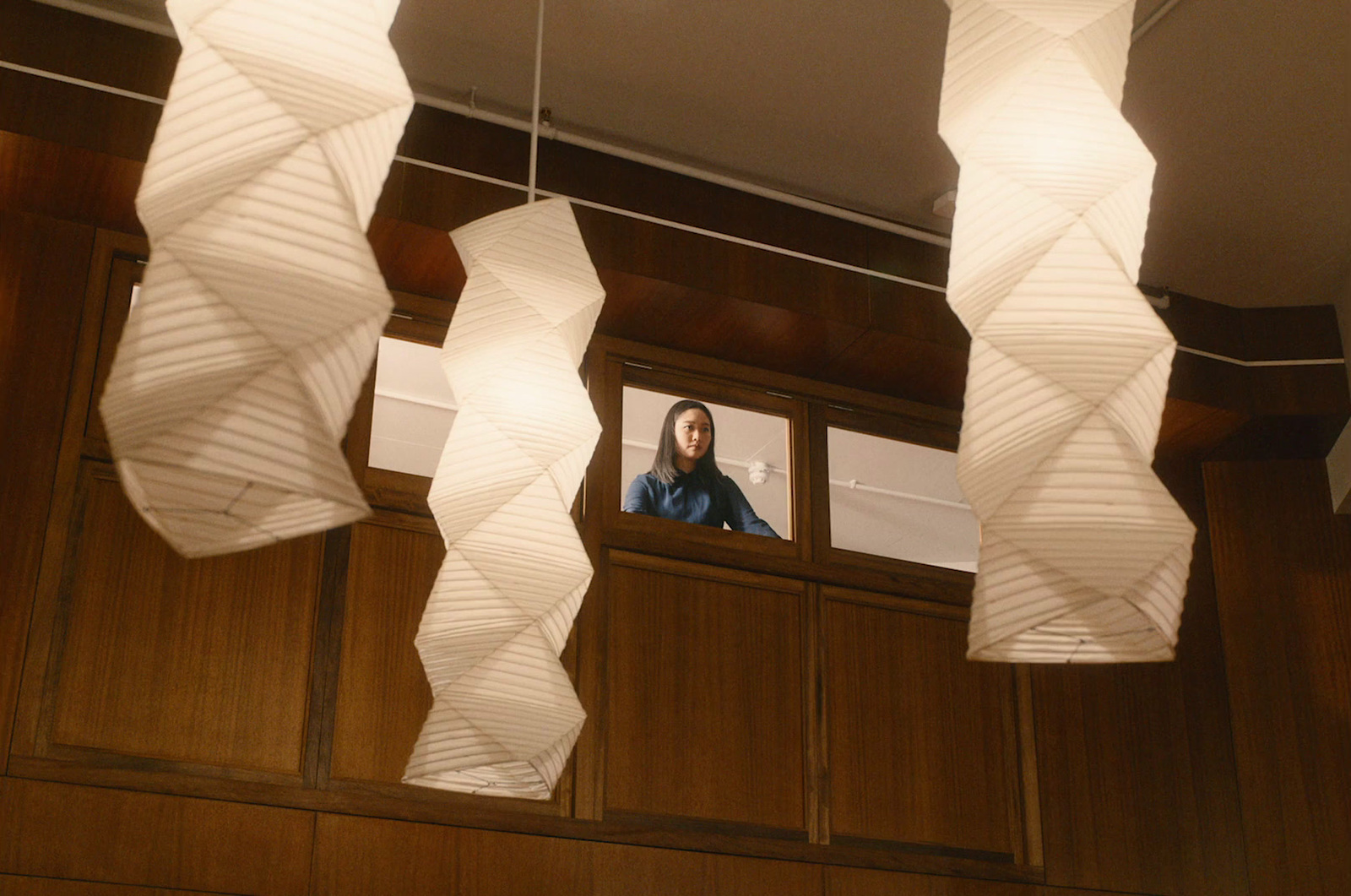 a woman is looking out of a window in a room