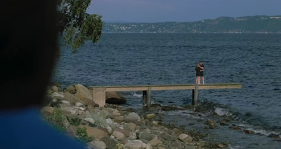 a person standing on a dock over a body of water