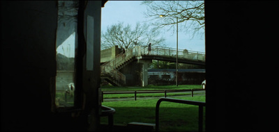 a view of a grassy area with a bridge in the background