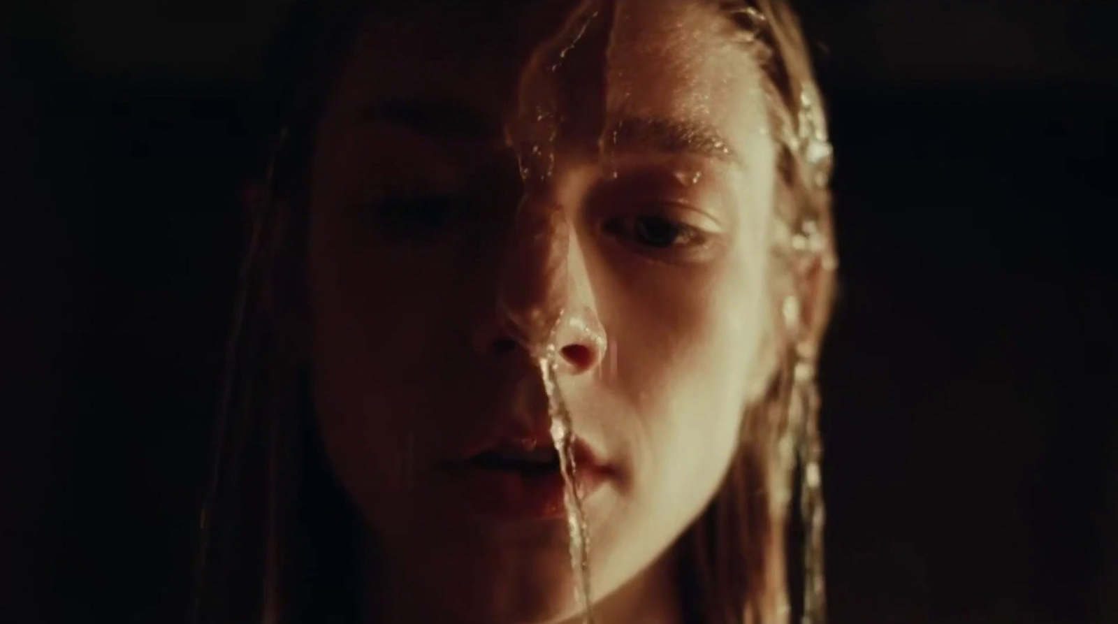 a woman with long hair and water dripping from her mouth