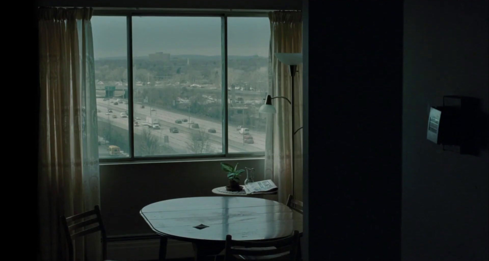 a table with a potted plant on top of it in front of a window