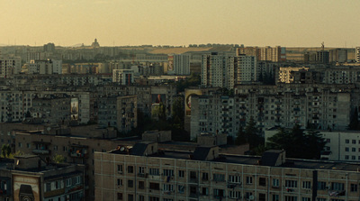 a view of a city with a plane flying in the sky