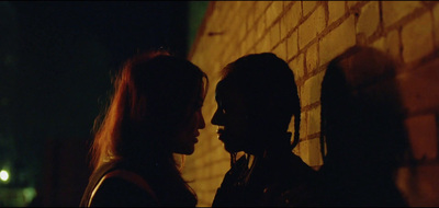 a couple of people standing next to a brick wall