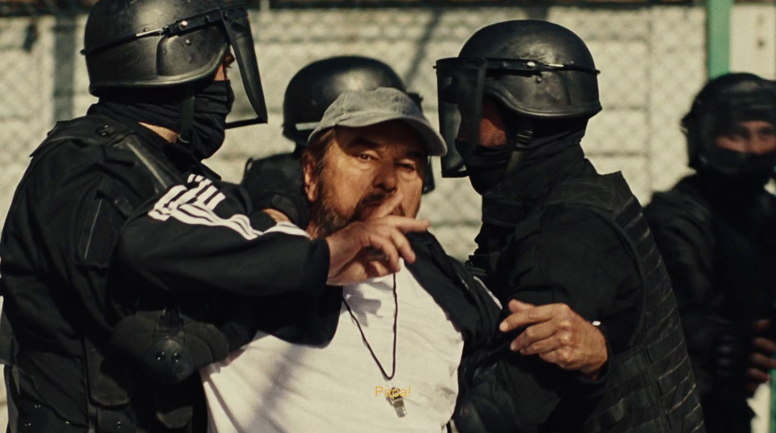 a man in a white t - shirt is surrounded by police