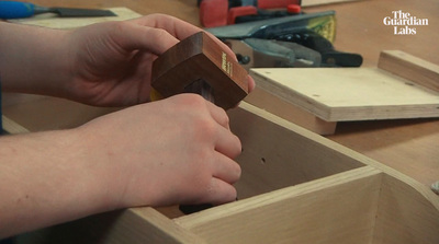 a person holding a piece of wood in a drawer