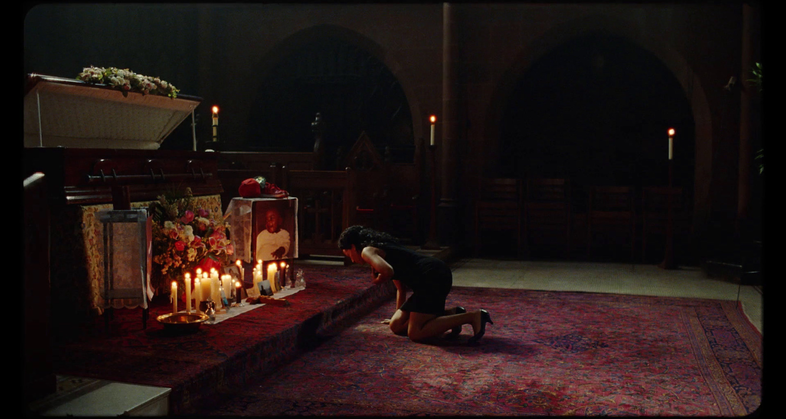 a woman kneeling down next to a bunch of candles