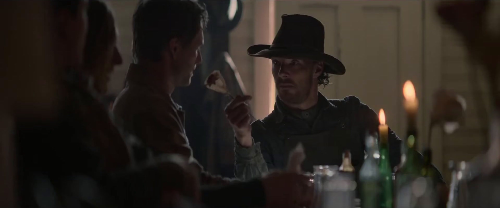 a man in a hat sitting at a table