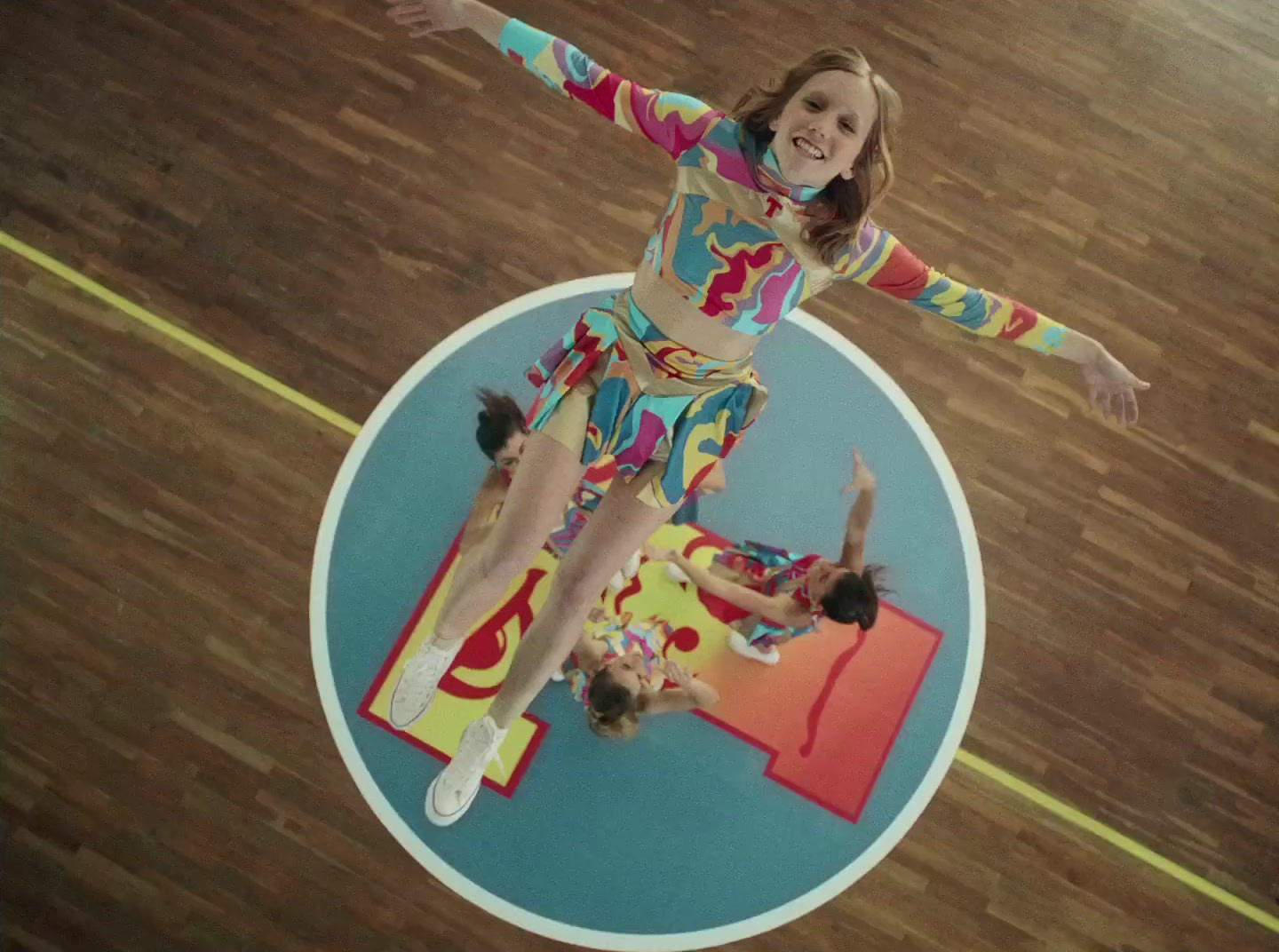 a woman in a colorful outfit standing on a basketball court