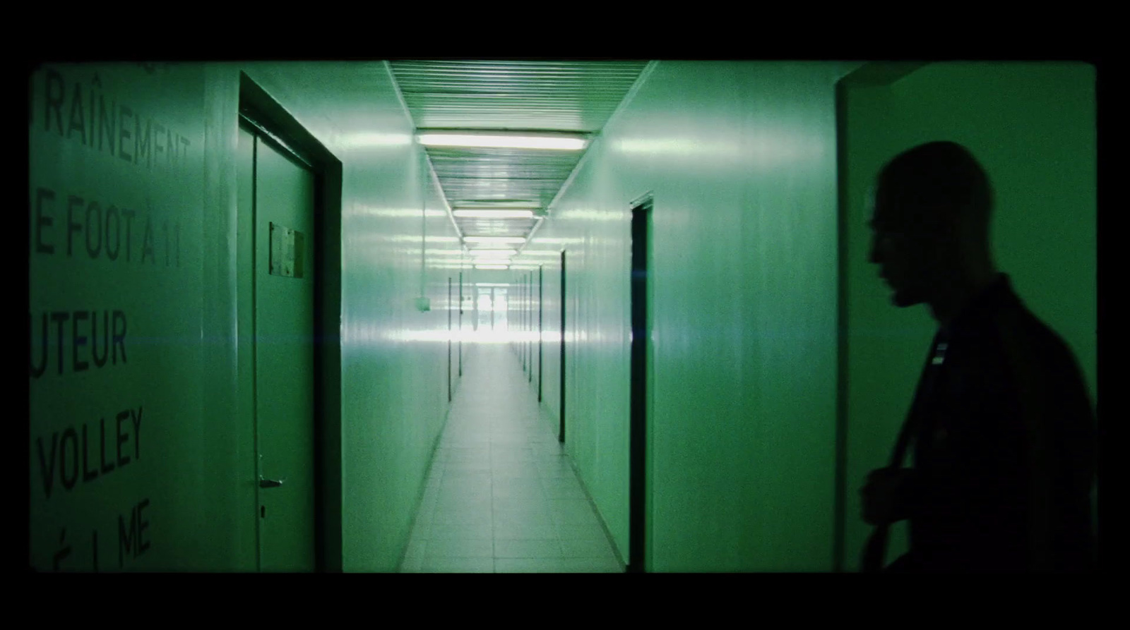 a man is walking down a long hallway