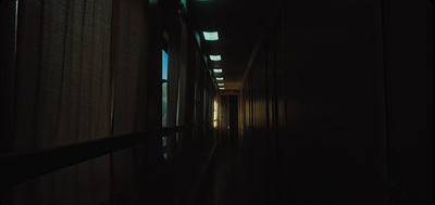 a long dark hallway with light coming through the windows