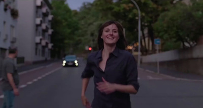 a woman walking down a street next to a man