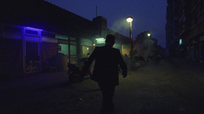 a man walking down a street at night